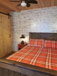 Muskoka Shores Cottages في ميناء كارلينج: غرفة نوم بسرير ومروحة سقف