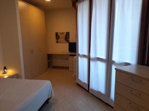 a bedroom with a bed and a desk and a window at FIERA LEVANTE in Bologna