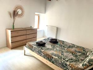 a bedroom with a bed and a dresser in it at Appartement La Tour in Vesoul