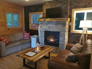 sala de estar con sofá y chimenea en Muskoka Shores Cottages, en Port Carling