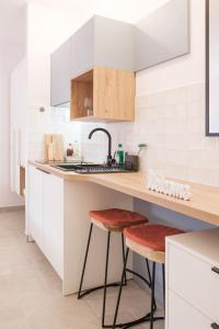 a kitchen with white cabinets and a sink and two stools at House Mateja Unije in Unije +23 photos