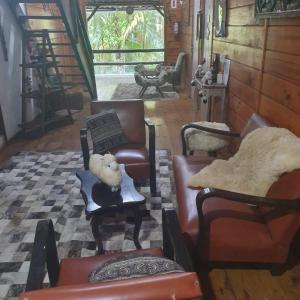 ein Wohnzimmer mit Stühlen und Möbeln in der Unterkunft Sítio do Sol quádruplo wc privativo in Guabiruba
