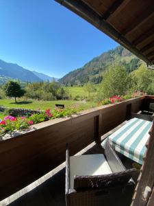 a balcony with two chairs and a table and flowers at Zimmer Haus Christina in Großkirchheim