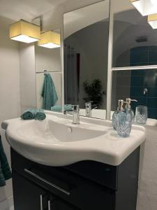 a bathroom with a white sink and a mirror at city center Santorín in Banská Bystrica