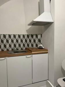 a small kitchen with a sink and a checkered wall at city center Santorín in Banská Bystrica