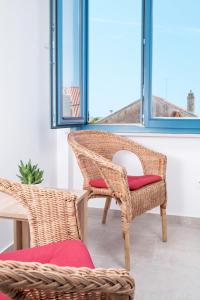 twee rieten stoelen met rode kussens in een kamer bij House Mateja Unije in Unije