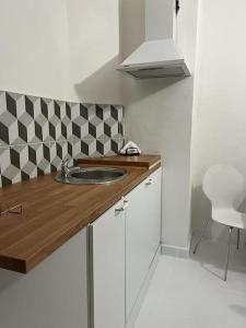 a small kitchen with a sink and a chair at city center Santorín in Banská Bystrica