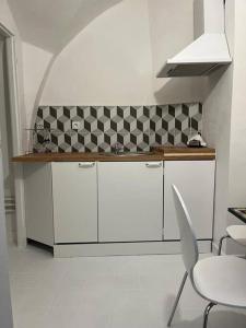 a kitchen with white cabinets and a table and chairs at city center Santorín in Banská Bystrica