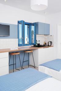 a kitchen with blue cabinets and a counter with stools at House Mateja Unije in Unije