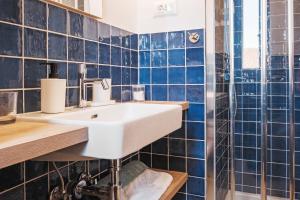 a bathroom with blue tiled walls and a white sink at House Mateja Unije in Unije