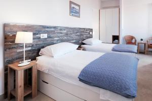 a bedroom with two beds and a brick wall at House Mateja Unije in Unije