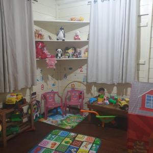 een kamer met een tafel, stoelen en speelgoed bij Sítio do Sol quádruplo wc privativo in Guabiruba