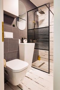 uma casa de banho com um WC e uma cabina de duche em vidro. em Modern studio D-va N em Zalău