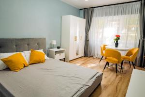 um quarto com uma cama, uma mesa e cadeiras em Modern studio D-va N em Zalău