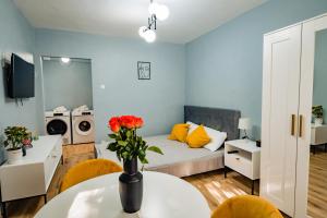 um quarto com uma cama e uma mesa com flores em Modern studio D-va N em Zalău