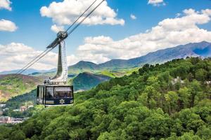 a gondola ride in the mountains with trees at Mins to Gburg Sleeps 8 Hot Tub Arcade Area Pool in Gatlinburg