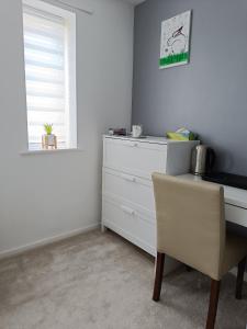 a bedroom with a desk and a chair and a window at Comfortable room in Yeovil near A303 exit & Football Club in Montacute