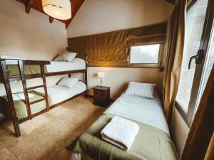 - une chambre avec 2 lits superposés et une chaise dans l'établissement El Refugio de Montaña, à San Martín de los Andes