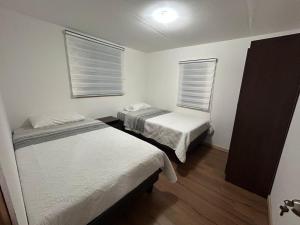 Cette chambre comprend 2 lits et 2 fenêtres. dans l'établissement Cabaña Freirina, à Freirina