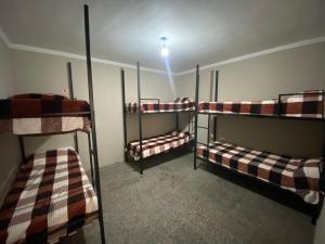 three bunk beds in a room with a light on at Urban Jungle Hostel in San Miguel de Tucumán +62 photos