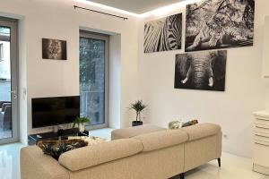 sala de estar con sofá y TV de pantalla plana en African Paradise with Jacuzzi & Sauna, en Viena