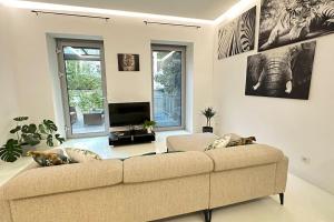 een woonkamer met een bank en een televisie bij African Paradise with Jacuzzi & Sauna in Wenen