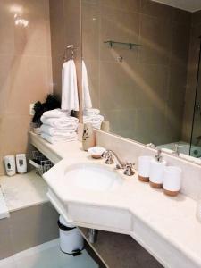 W łazience znajduje się umywalka, lustro i ręczniki. w obiekcie Green Park Punta del Este w mieście Punta del Este