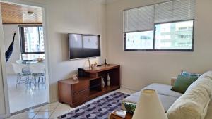 sala de estar con sofá y TV de pantalla plana en Apartamento na Praia Central de BC, ideal para você e sua família, en Balneário Camboriú