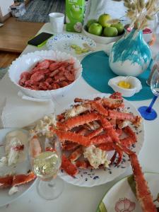 a table topped with plates of food with shrimp and other foods at SAGA Overnatting in Kirkenes