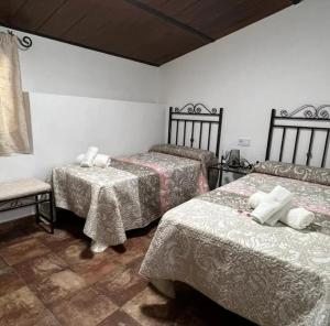 a room with three beds and a chair in it at Casa la limosna in Setenil