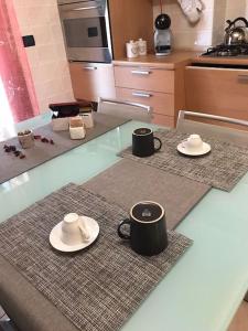 two cups and saucers on a counter in a kitchen at Appartamento Elegante, Romantico e Riservato in Palazzolo dello Stella