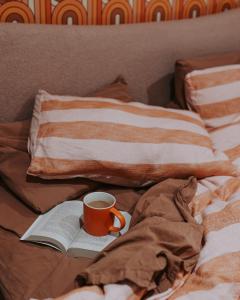 a cup of coffee and an open book on a bed at The Greeen Room in Launceston