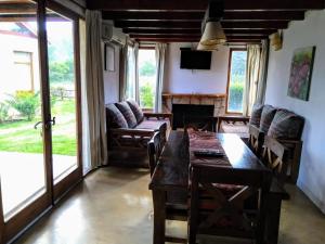 comedor con mesa, sillas y sofá en Cabañas Ayres del Lago 2 en Potrero de los Funes