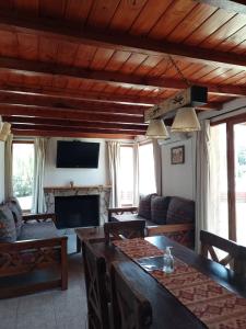 sala de estar con mesa, sofá y TV en Cabañas Ayres del Lago 2 en Potrero de los Funes