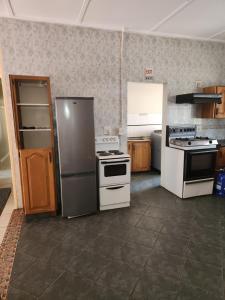 a kitchen with a refrigerator and a stove at HUNTERS NEST GUEST HOUSE MAFIKENG in Mahikeng