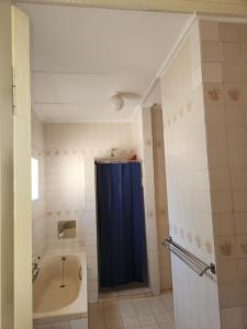 a bathroom with a tub and a blue shower curtain at HUNTERS NEST GUEST HOUSE MAFIKENG in Mahikeng +72 photos
