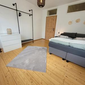 um quarto com uma cama e um tapete num piso de madeira em Ferienwohnung an der Stadtmauer em Warburg