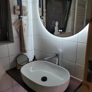 a white sink in a bathroom with a mirror at Ferienwohnung an der Stadtmauer in Warburg