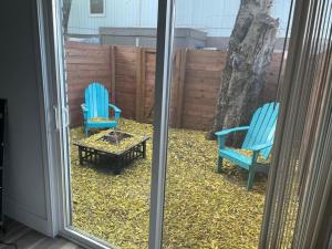 2 chaises bleues et une table à l'extérieur d'une fenêtre dans l'établissement Casa Wooten - Pet Friendly, à Austin
