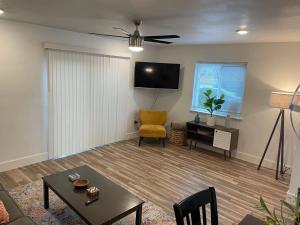 ein Wohnzimmer mit einem Tisch und einem gelben Stuhl in der Unterkunft Casa Wooten - Pet Friendly in Austin