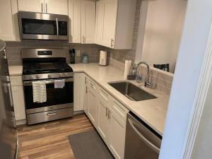 a kitchen with a stove and a sink and a microwave at Casa Wooten - Pet Friendly in Austin