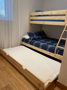 2 stapelbedden in een kleine kamer met een raam bij MODERN BILBAO in Barakaldo