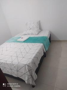 uma cama num quarto ao lado de uma parede em Apartamento la 20 em Pereira