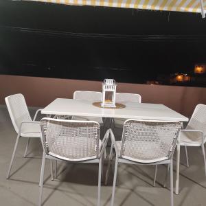 een witte tafel en stoelen met een kaars erop bij CASA ROSAMAR in Agulo