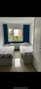 two beds in a room with a window at Ferienwohnung Köln in Cologne