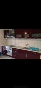 a kitchen with red cabinets and a sink at Ferienwohnung Köln in Cologne