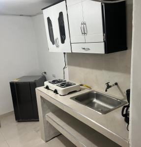 una cucina con lavandino e piano cottura di Apartamento la 20 a Pereira