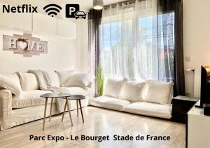 a living room with a white couch and a table at VIP Lounge Villa - Parc expo - Le Bourget - Stade France in Mitry-Mory