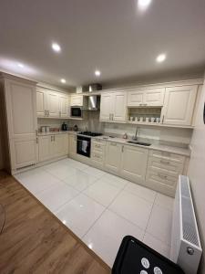 uma cozinha com armários brancos e piso em azulejo branco em Coastal Dublin, 4 adult bed spaces+child max em Dublin