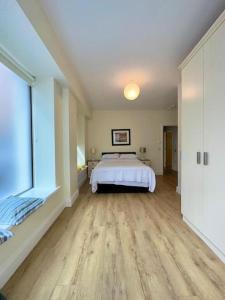 a large bedroom with a bed and a large window at Coastal Dublin, 4 adult bed spaces+child max in Dublin